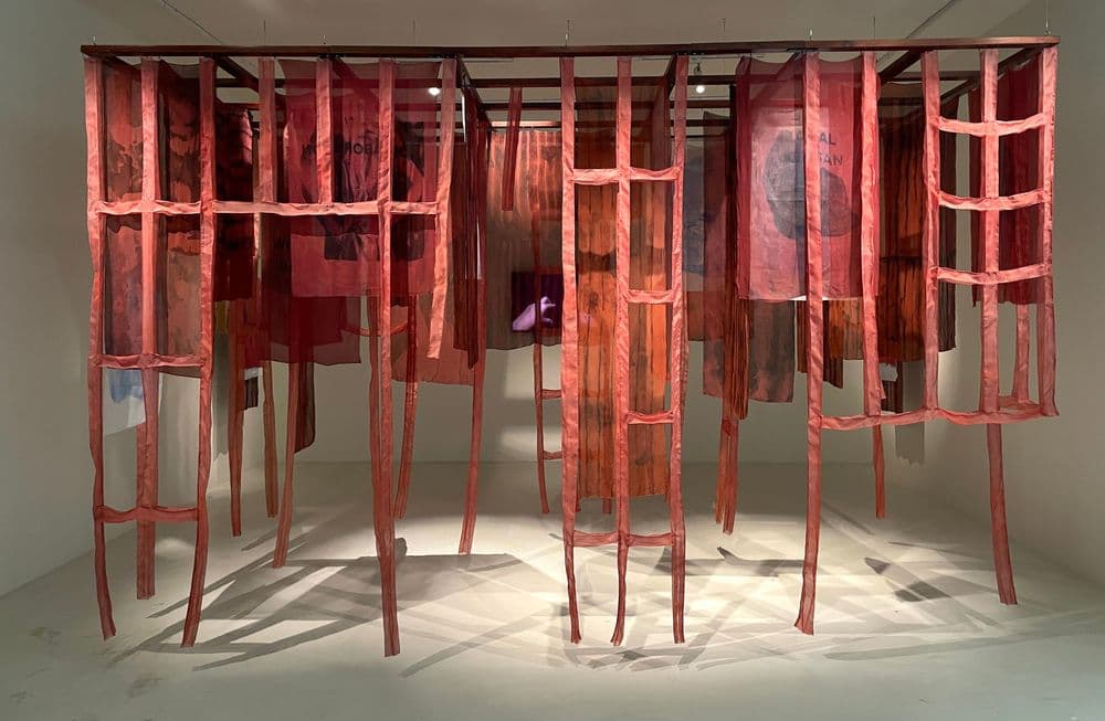 Dian Suci, "Beneath Fingers: Echoing Through the Shadow of a Still House", 2025, stampa su tessuto monyl, pasta mordente su seta tinta con coloranti vegetali, serigrafia con pasta mordente su seta tinta con coloranti vegetali, legno di teak, lastre di acrilico, finestra in legno di teak, video © and ph. Dian Suci