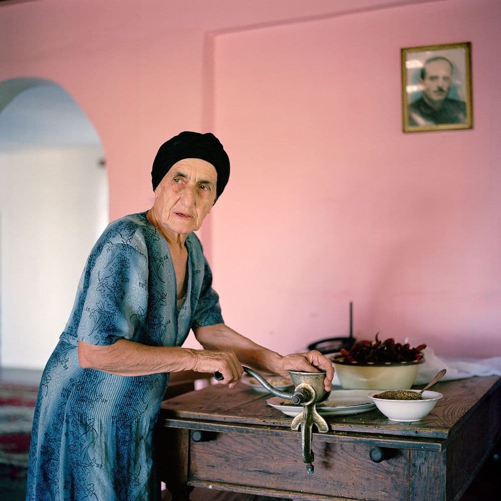 Ivor Prickett, "Tengo Inalishvili’s mother makes a spicy paste from dried chilies at the Inlaishvili family home in the village of Rechxi." 2010, Rechxi, Abkhazia Photography from the series “Returning Home – Abkhazia” © Ivor Prickett  